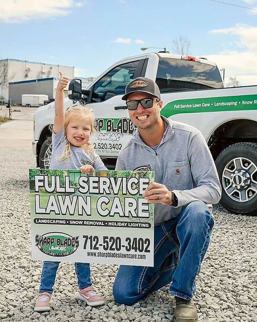 Dylan, owner of Sharp Blades Lawn Care, outside the shop with a company truck